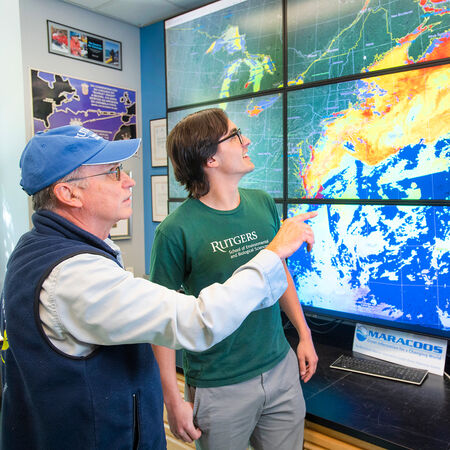 Student and professor discussing a meteorological incident on a screen 